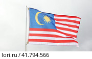 Large flag of Malaysia fixed on metal stick waving against background of cloudy sky during daytime. Стоковое видео, видеограф Яков Филимонов / Фотобанк Лори