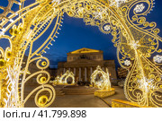 Большой театр, Москва, Россия. Вид на Театральную площадь и здание Большого театра. Вечерний городской пейзаж. Красивое новогоднее украшение города. Арка из светящихся гирлянд. Праздничное настроение. Туристическая достопримечательность. Редакционное фото, фотограф Андрей Степанов / Фотобанк Лори