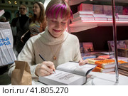Писательница Мария Сакрытина подписывает свои книги для читателей на международной ярмарке интеллектуальной литературы Non/fiction в Гостином дворе города Москвы, Россия (2023 год). Редакционное фото, фотограф Николай Винокуров / Фотобанк Лори