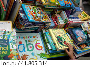 Детские книжки на английском языке лежат на прилавке магазина на международной ярмарке интеллектуальной литературы Non/fiction в Гостином дворе города Москвы, Россия (2023 год). Редакционное фото, фотограф Николай Винокуров / Фотобанк Лори