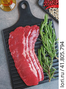 Стейк "Минутка" из мраморной говядины Black Angus. Куски сырой мраморной говядины Black Angus для гриля на деревянной доске на темном фоне. Стоковое фото, фотограф Оксана Медведева / Фотобанк Лори