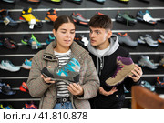 Couple examine view several item of winter comfortable trecking shoes. Стоковое фото, фотограф Яков Филимонов / Фотобанк Лори