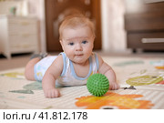 малыш лежит на полу играется с мячиком. Стоковое фото, фотограф Юлия Можина / Фотобанк Лори