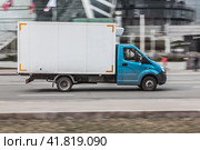 Gazelle rides on the road. White and cyan cargo van GAZ Gazelle Next driving in the street. (2021 год). Редакционное фото, фотограф Константин Григорьев / Фотобанк Лори
