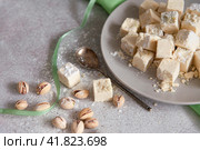 Pistachios halvah on plate with pistachios nuts with green cloth on gray background, macro, close up, selective focus. Стоковое фото, фотограф Вера Крутилина / Фотобанк Лори