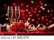 A top-down view showcasing red hearts, candles, and gifts on a wooden table. Стоковое AI-изображение, AI-художник Галина Царькова / Фотобанк Лори