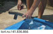 Man assembling the metal base of a frame pool in the backyard. A close-up of the assembler's hands. Installing a pool for the summer season. Стоковое видео, видеограф Воловодов Владимир / Фотобанк Лори