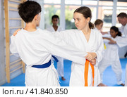 Teenage girl working on martial arts skills in pair with boy during training. Стоковое фото, фотограф Яков Филимонов / Фотобанк Лори