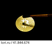 Brush brush dust from golden bitcoin on a black background. Стоковое фото, фотограф Дмитрий Львович Алферов / Фотобанк Лори