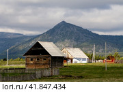 the village of Verkhnearshinsky in the Beloretsk region of Bashkortostan against the backdrop of the Kumardak ridge on a cloudy day. Стоковое фото, фотограф Акиньшин Владимир / Фотобанк Лори