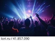 People from behind with their arms raised in the air dancing at a concert under neon lighting. Party. Стоковое AI-изображение, AI-художник Коханова Наталья / Фотобанк Лори