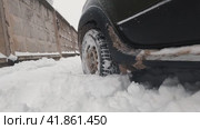 The front wheel with winter studded tires starts abruptly in front of the camera in deep snow. Стоковое видео, видеограф Ярославский Максим / Фотобанк Лори