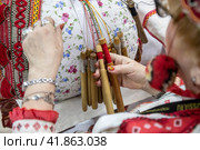 Крупным планом мастерица ткет михайловское кружево на стенде Рязанской области на выставке-форуме "Россия" в городе Москве, Россия (2023 год). Редакционное фото, фотограф Николай Винокуров / Фотобанк Лори