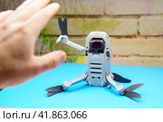 Квадрокоптер Dji Mini 2 сидит на столе и приветствует человека взмахом руки, во время запрета на полеты дронов (2023 год). Редакционное фото, фотограф Sergei Gorin / Фотобанк Лори