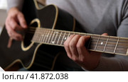 Playing the guitar. Strumming acoustic guitar. Musician plays music. Man fingers holding mediator. Man hand playing guitar neck in dark room. Unrecognizable person rehearsing, fretboard close-up. Стоковое видео, видеограф Марина Демидюк / Фотобанк Лори
