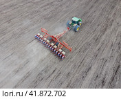 Sowing of corn. Tractor with a seeder on the field. Using a seeder for planting corn. Стоковое фото, фотограф Леонид Еремейчук / Фотобанк Лори