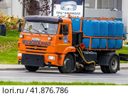 Moscow municipal service truck drive on city streets. Orange KAMAZ watering and sweeping truck in motion. Редакционное фото, фотограф Константин Григорьев / Фотобанк Лори