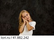 Portrait of darling girl child model in white t-shirt expression emotion, sweet looking at camera. Smiling cover kid 6 year old posing at black, studio shot. Kids emotional concept. Copy ad text space. Стоковое фото, фотограф Aleksandr Golubev / Фотобанк Лори