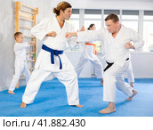 Man father is paired with coach to learn how to strike and rehearses blocking opponent. Стоковое фото, фотограф Яков Филимонов / Фотобанк Лори