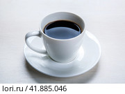 White cup with black coffee and saucer on the table. Стоковое фото, фотограф Александр Калугин / Фотобанк Лори