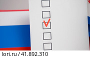 Moscow December 20 2023, Presidential elections in Russia in 2024 concept, election paraphernalia, flag of Russia, ballute for voting in the presidential elections in Russia. Редакционное фото, фотограф Скрипачев Антон / Фотобанк Лори