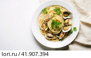 Spaghetti alle vongole with tomato in seafood jus served as close-up at a Nordic design bowl with copy space. Стоковое AI-изображение, AI-художник Ирина Ручушкина / Фотобанк Лори