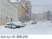 Magadan, Magadan Region, Siberia, Russia. Snow covered city street. A lot of snow on the roadway, sidewalks and cars after a snowfall and a snowstorm. Cold snowy weather. Редакционное фото, фотограф Андрей Степанов / Фотобанк Лори