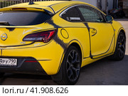 Opel Astra J GTC car in yellow vinyl film parked on the street in the city. Редакционное фото, фотограф Константин Григорьев / Фотобанк Лори