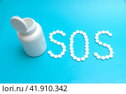 White tablets on a blue background laid out in the form of letters SOS. Стоковое фото, фотограф Ярославский Максим / Фотобанк Лори