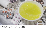 A man's hand puts a yellow effervescent tablet into a white mug. The tablet dissolves in water. Стоковое видео, видеограф Ярославский Максим / Фотобанк Лори