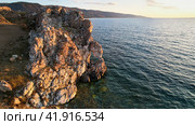 Lake Baikal at sunset. A rock with a hole in the shape of a heart on Cape Tsagan-Khushun. Стоковое фото, фотограф Виктория Тельминова / Фотобанк Лори