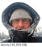Severe frosts outside. A frostbitten man in a winter jacket on the street. Стоковое фото, фотограф Александр Поташев / Фотобанк Лори