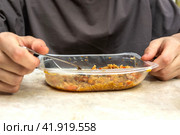A man eats pilaf from disposable plastic dishes with a fork. Стоковое фото, фотограф Ярославский Максим / Фотобанк Лори
