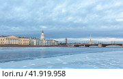 View of the winter, icy Neva embankment with the building of the Kunstkammer Museum in winter St. Petersburg. Ice on the Neva River in St. Petersburg at sunset in winter. Редакционное фото, фотограф Дмитрий Пресняков / Фотобанк Лори