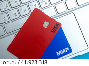 Карты VISA и МИР  на клавиатуре ноутбука. Краеугольный камень экономики. (2024 год). Редакционное фото, фотограф Ярославский Максим / Фотобанк Лори