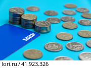 Платежная карта МИР с россыпью рублевых монет на голубом фоне (2024 год). Редакционное фото, фотограф Ярославский Максим / Фотобанк Лори