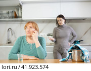 Adult woman and young woman during quarrel in kitchen. Стоковое фото, фотограф Яков Филимонов / Фотобанк Лори