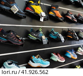 On black wooden wall of showcase - there are samples of models of hiking and climbing shoes (2023 год). Редакционное фото, фотограф Яков Филимонов / Фотобанк Лори