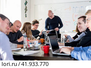 Startup business and entrepreneurship problem solving. Young AI programmers and IT software developers team brainstorming and programming on desktop computer in startup company share office space. Стоковое фото, фотограф Matej Kastelic / Фотобанк Лори
