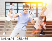 Happy smiling teenagers practicing vigorous hip hop movements at street. Стоковое фото, фотограф Яков Филимонов / Фотобанк Лори