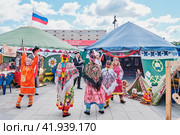People in traditional festive clothes of ethnic groups of Urals dancing at Irbit Fair, Russia (2023 год). Редакционное фото, фотограф Ирина Кононова / Фотобанк Лори