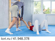 Self-defense trainer teaching young woman how to do painful holds on an attacker arm in gym. Стоковое фото, фотограф Яков Филимонов / Фотобанк Лори