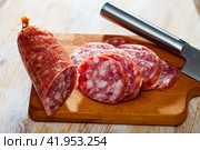 Thin salchichon sausage slices on wooden background, view from above. Стоковое фото, фотограф Яков Филимонов / Фотобанк Лори