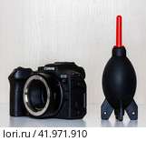 Krasnodar, Russia - December 28, 2023: mirrorless camera Canon eos r7 with adapter for lenses with EF, EF-S mount and rubber Blower for removal of dust from the camera and optics. Редакционное фото, фотограф Андрей С / Фотобанк Лори