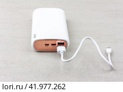 White power bank for charging smartphones and various digital devices on a grey background close-up. Стоковое фото, фотограф Андрей С / Фотобанк Лори