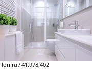Spacious bathroom in white Design with heated floors, walk-in shower, sink vanity and skylights. Стоковое AI-изображение, AI-художник Ирина Ручушкина / Фотобанк Лори