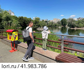 Папа с ребенком наблюдают за птицами на Большом Пресненском пруде в Московском зоопарке летом. Россия, Москва. Редакционное фото, фотограф Овчинникова Ирина / Фотобанк Лори