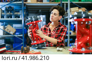 Female worker assembles shutoff valves using various tools in factory indoor. Стоковое фото, фотограф Яков Филимонов / Фотобанк Лори