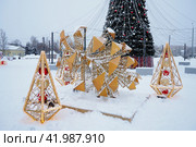 Petrozavodsk, Russia, January 10 2024: Small architectural forms in the form of luminous cones and a large cone, made of garlands and light bulbs. Festive decoration of city streets and squares. Xmas. Редакционное фото, фотограф Юлия Петровская / Фотобанк Лори