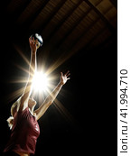 A blonde girl in a jump takes a ball from a pitch on a dark background. Close-up. The concept of gaming sports. Стоковое AI-изображение, AI-художник Ярославский Максим / Фотобанк Лори